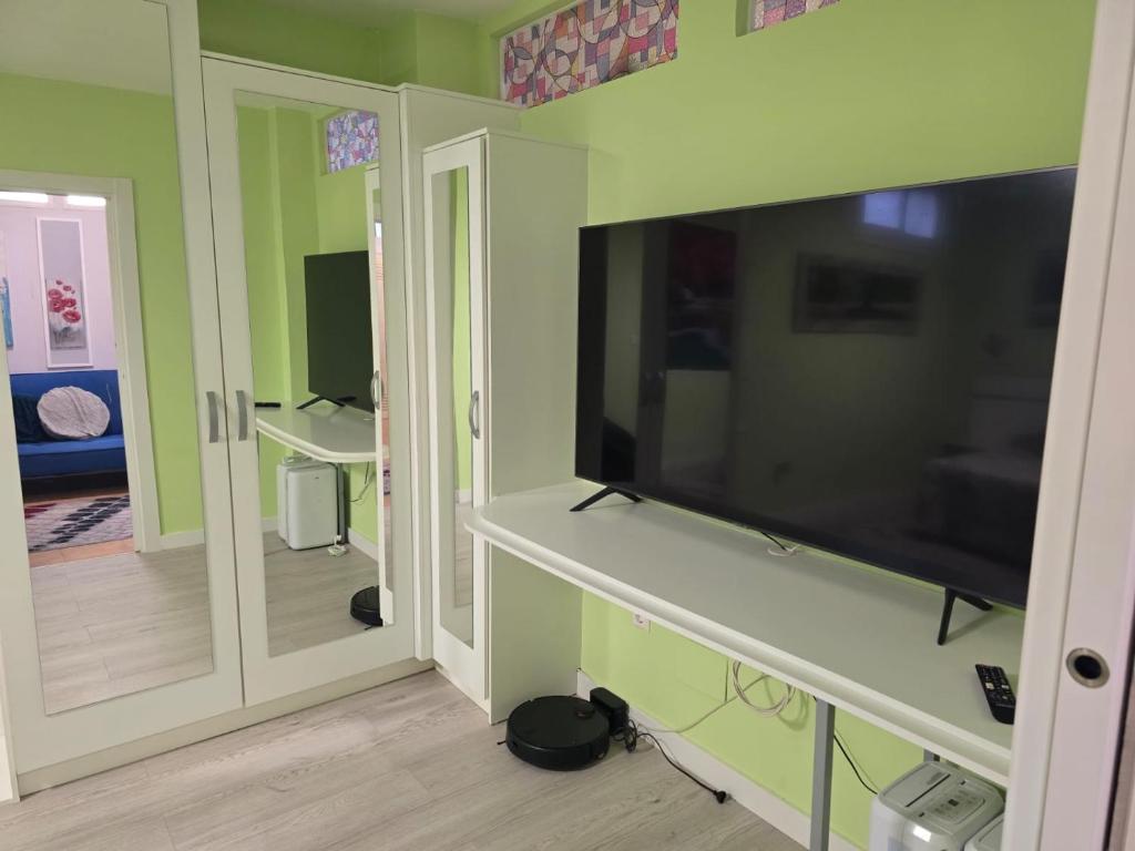 Dormitorio de Villa Maritxu en Cangas do Morrazo con armario amplio, televisión y mobiliario moderno para alojamiento turístico en O Morrazo