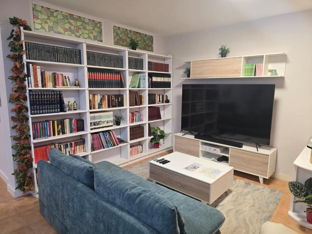 Salón de Villa Maritxu en Cangas do Morrazo con biblioteca, televisión de gran formato y zona de descanso para estancias turísticas en O Morrazo